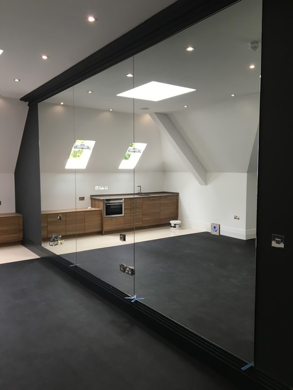 Frameless glass partition in loft conversion by Harrow glaziers