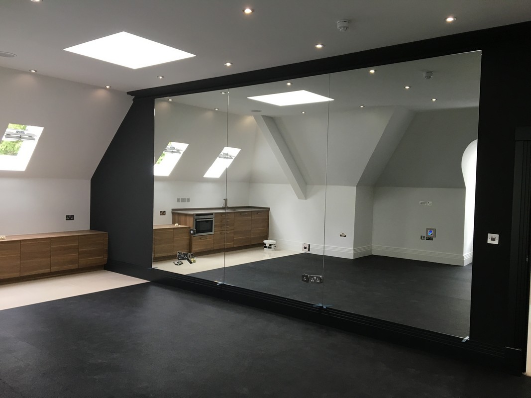 Frameless glass wall dividing loft conversion in Harrow